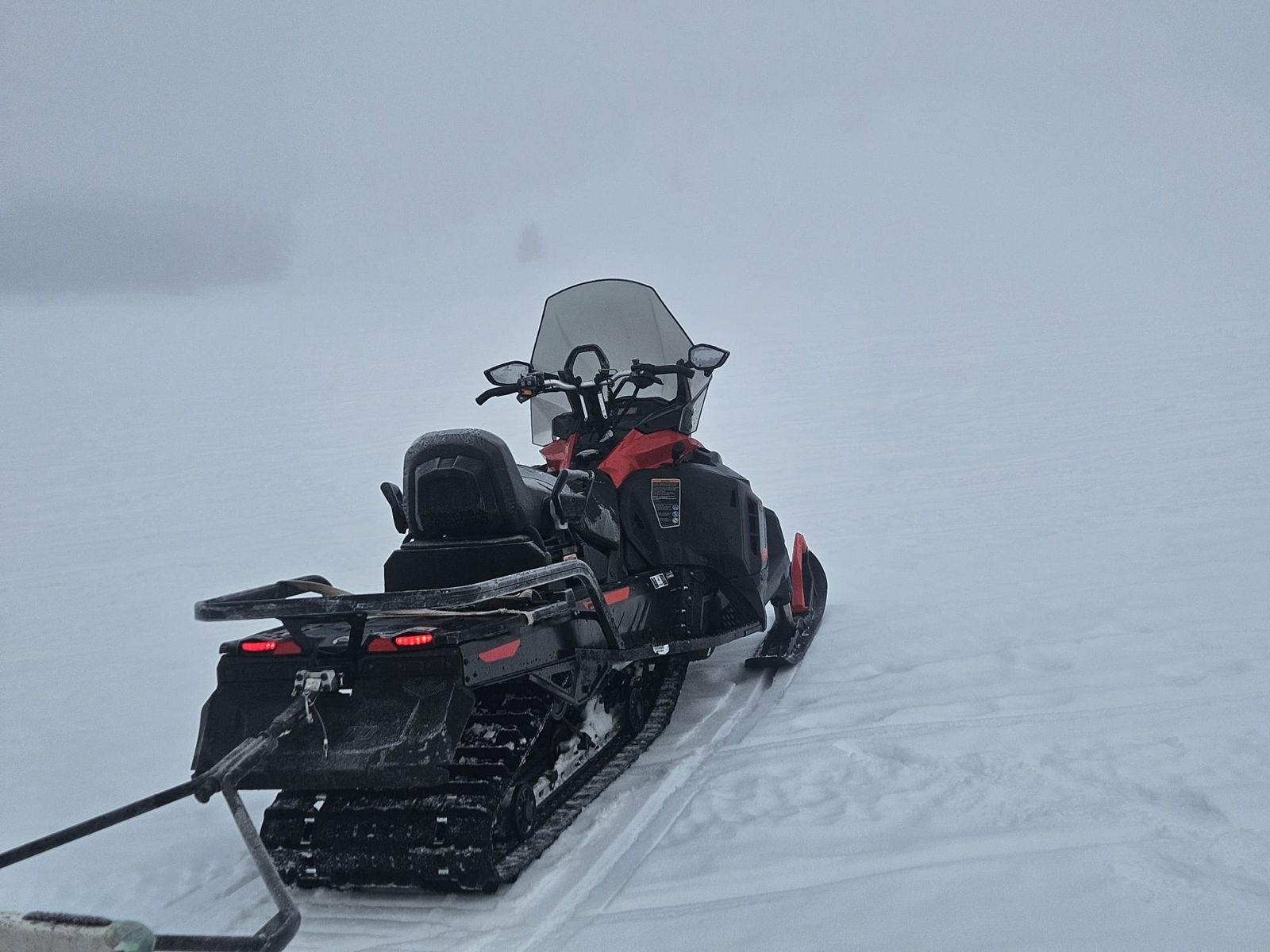 Motoneige à l'arrêt dans la brume sur un lac gelé